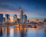 Frankfurter Skyline bei Sonnenuntergang mit Main und Brücke.