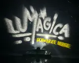 LUMAGICA Schwarze Berge Schriftzug auf Wasserprojektion bei Nacht.