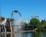 Achterbahn im Heide Park mit Wassereffekt und einem großen Holzmonster.