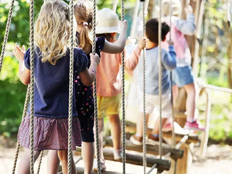 Kinder spielen auf einem Abenteuerspielplatz in Berlin